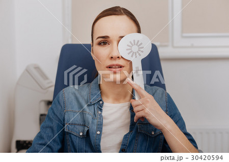 Nice pleasant woman closing her left eye Nice pleasant woman closing her left eye 30420594