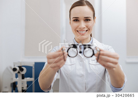 Joyful friendly optometrist offering you eye test 30420665