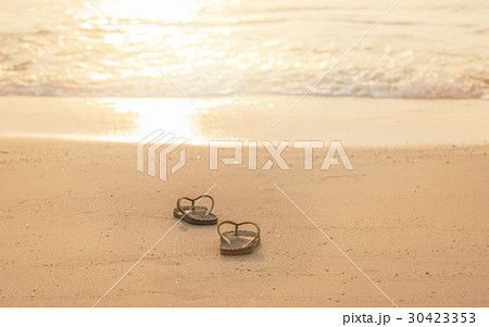 silhouette flip flop shoes on the beach in sunset silhouette flip flop shoes on the beach in sunset 30423353