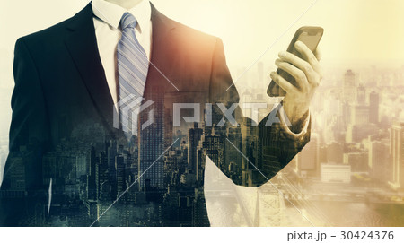 Double exposure of business man with smartphone and city 30424376