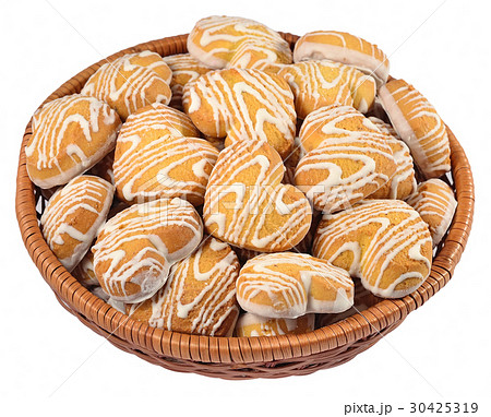 Cookies in heart shape in a wicker bowl on a white Cookies in heart shape in a wicker bowl on a white 30425319