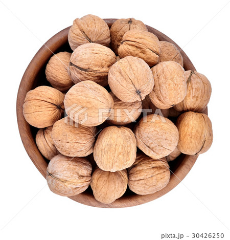 Whole walnuts in a wooden bowl on a white Whole walnuts in a wooden bowl on a white 30426250
