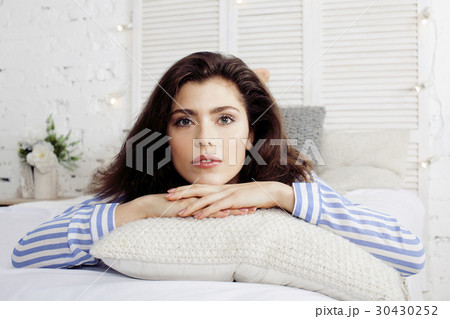 young pretty brunette woman in her bedroom sitting 30430252