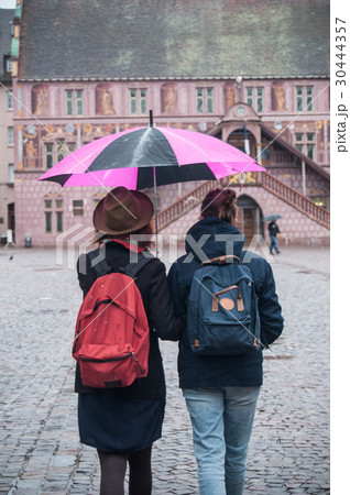 couple with pink umbrella on cobbles place couple with pink umbrella on cobbles place 30444357