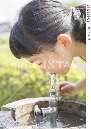 公園で水を飲む子供の写真素材