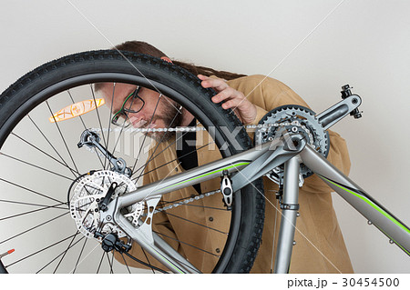Bearded caucasian man repairing  the mtb bicycle 30454500