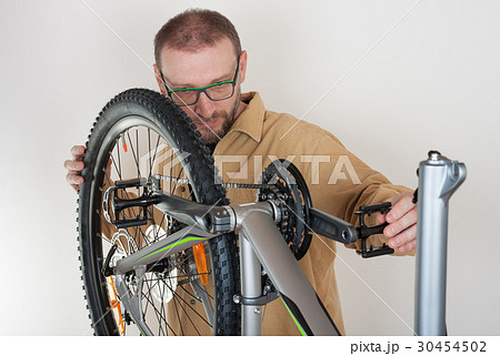Bearded caucasian man repairing  the mtb bicycle 30454502