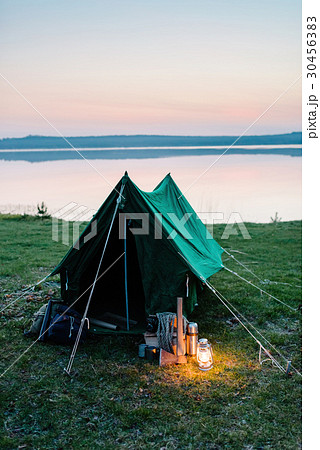 Tent on the shore of a lake, a lantern 30456383