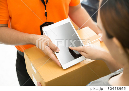 Woman appending signature on tablet 30458966