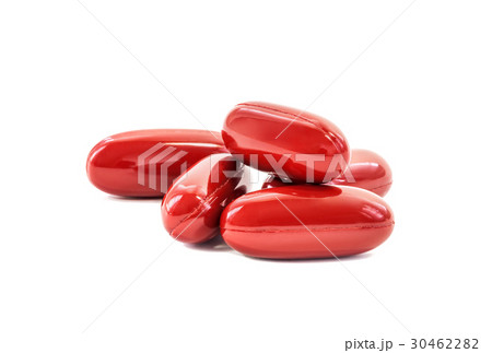 Red supplement capsules on white background 30462282