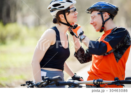 Pair of cyclists wear helmets 30463086