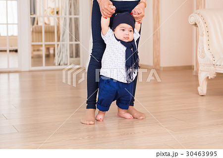 Mom teaching her son's first baby steps indoors 30463995