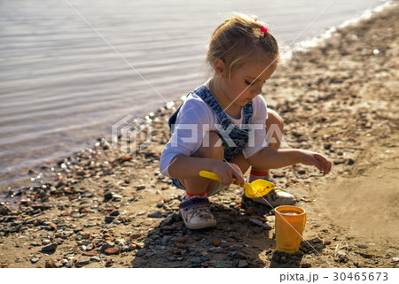 cute little girl play with sand and shovel on 30465673