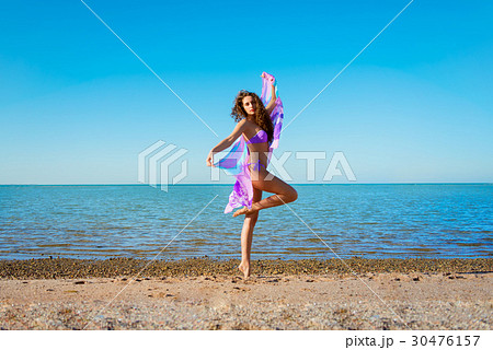 Young woman with curly hair  posing  with pareo  30476157