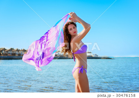 Young woman with curly hair  posing  with pareo  30476158