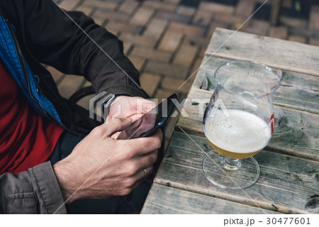 Man texting on phone while drinking beer Man texting on phone while drinking beer 30477601