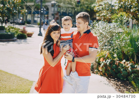 beautiful family in red walking down the street 30484730
