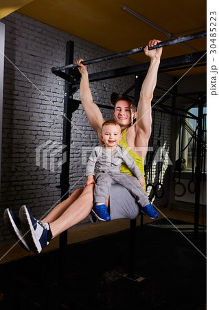 Young athlete father hangs on the horizontal bars 30485223