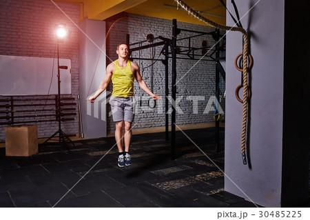 Athlete man in the sportwear using jump ropes for 30485225