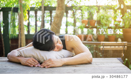 Young Asian man sleeping in a garden. Young Asian man sleeping in a garden. 30486177