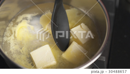 Handheld shot of butter melting in water 30488657