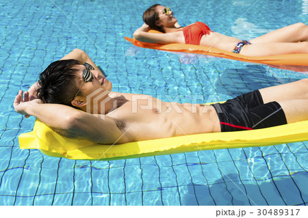 young couple relaxing on inflatable raft young couple relaxing on inflatable raft 30489317