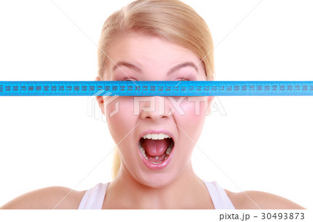 Fitness girl fit woman covering her eyes with measuring tape Fitness girl fit woman covering her eyes with measuring tape 30493873