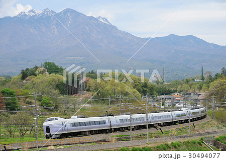 八ヶ岳を望むカーブを走り去る中央線特急スーパーあずさ号 30494077