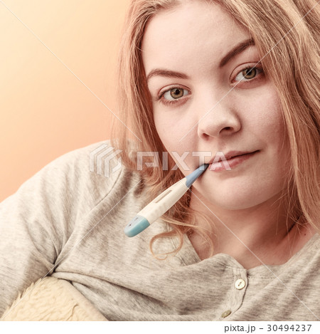 Sick ill woman with digital thermometer in mouth. 30494237