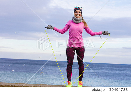 Woman training outdoor with jump rope on cold day 30494788