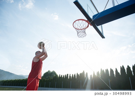Young man jumping and making a fantastic slam dunk Young man jumping and making a fantastic slam dunk 30498993