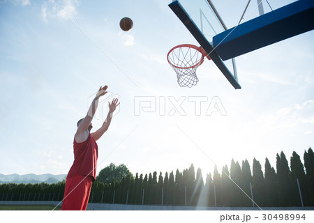 Young man jumping and making a fantastic slam dunk 30498994