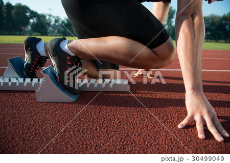 Runners preparing for race at starting blocks Runners preparing for race at starting blocks 30499049