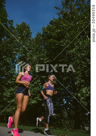 Athletic women exercising by jogging in nature 30499358