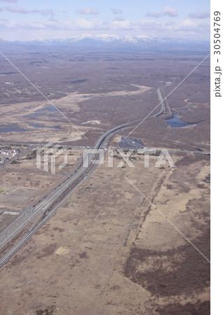 北海道苫小牧市ウトナイ北の上空から日高自動車道、国道36号線と遠い山々を上空から見る 30504769