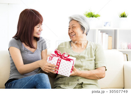 happy young woman giving present to grandmother happy young woman giving present to grandmother 30507749