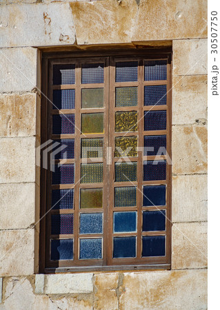 Closeup of colored window and stone wall 30507750