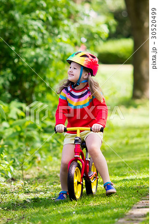 Kids ride balance bike in park 30520499