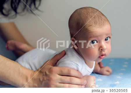 father holding a baby lying 30520505