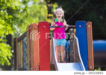 Child playing on outdoor playground in summer Child playing on outdoor playground in summer 30520665