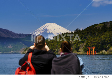 芦ノ湖の箱根神社の鳥居と富士山を見る外国人観光客 30524702