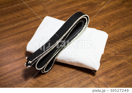 道場の床に置かれた道着（空手着、柔道着）と黒帯 30527249