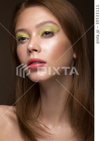 Beautiful red-hair girl with creative green makeup 30533111