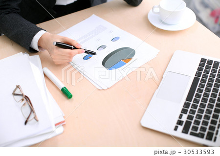 Business woman sitting at the table and examines Business woman sitting at the table and examines 30533593