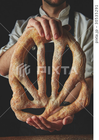 Baker holding fougas bread Baker holding fougas bread 30535291