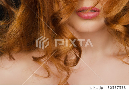 Beautiful curly long red hair on the face of woman Beautiful curly long red hair on the face of woman 30537538
