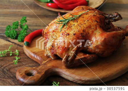 Whole roasted chicken on cutting board 30537591