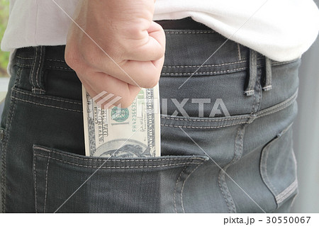 Hand of man putting "Dollars 30550067