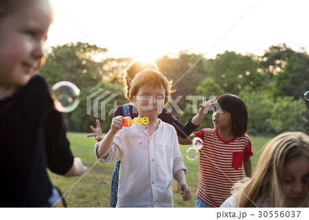 Group of kindergarten kids friends playing blowing bubbles fun Group of kindergarten kids friends playing blowing bubbles fun 30556037