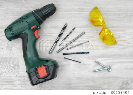 A cordless drill set on a wooden table background 30558404